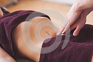 Close-up of masseur hands doing belly massage