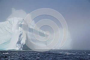 Close up of massive iceberg exiting fog