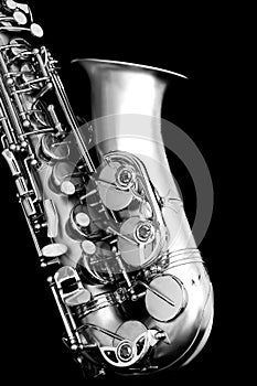 Close up of a matte finished alto saxophone in monochrome against  black background