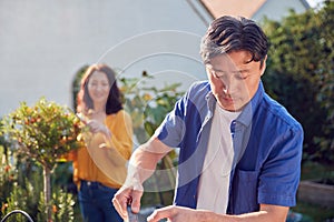 Close Up Of Mature Asian Couple At Work Watering And Caring For Plants In Garden At Home