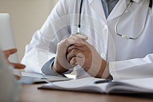 Close up mature doctor listening to patient complaints at meeting photo