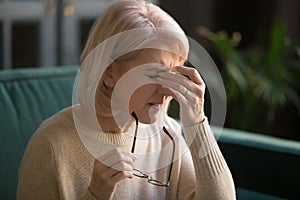 Mature woman massage eyes suffering from hypertension