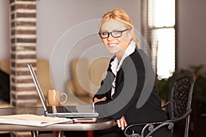 Close up of a mature lawyer smiling. Working at a desk. Laptop