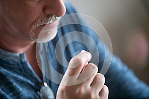Close up mature man holding in hand pill