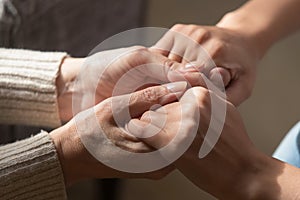 Close up of mature mom and daughter holding hands