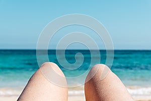 Mature woman legs sunbathing on the beach