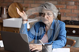 Close up mature woman wearing glasses making video call, internet negotiations