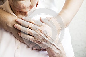 Close up of mature womans & nurse hands. Health care giving, nursing home. Parental love of grandmother. Old age related diseases.