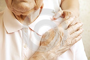 Close up of mature womans & nurse hands. Health care giving, nursing home. Parental love of grandmother. Old age related diseases.