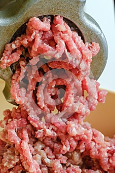 Close up meat grinder or mincing-machine with mincemeat in. Showing the forcemeat process