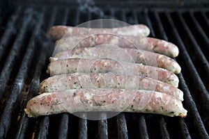 Close-up of meat sausages sizzling on a gas BBQ grill, Close-up of meat sausages sizzling on a gas BBQ grill,