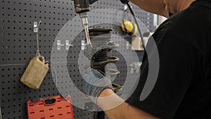 A close-up of a mechanic repairing shock absorbers in a modern auto repair shop.