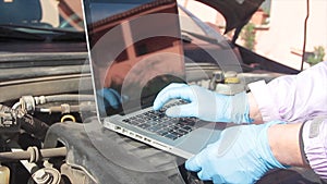 Close up of Mechanical hitch engine diesel tests using laptop on the air filter