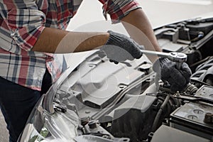 Close up mechanical man dirty hands using tool to fix repair car