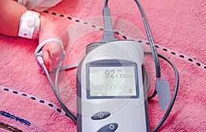 Close up Medical device, digital blood oximeter monitor measuring blood oxygen in newborn baby in baby care unit at hospital.