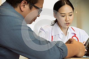 Close up medical doctor in white uniform gown coat interview and filling up an application form while consulting patient, medical