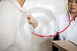 Close up medical doctor in white uniform gown coat interview and filling up an application form while consulting patient, medical