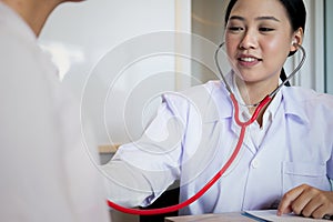 Close up medical doctor in white uniform gown coat interview and filling up an application form while consulting patient, medical