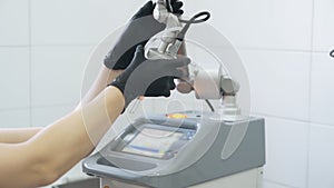 Close up medical equipment. Beautician takes electronic device, slow motion
