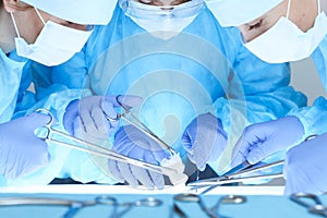 Close-up of medical team performing operation. Group of surgeons at work are busy of patient. Medicine, veterinary or
