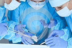 Close-up of medical team performing operation. Group of surgeons at work are busy of patient. Medicine, veterinary or