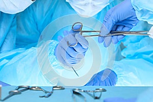 Close up of medical team performing operation. Group of surgeons at work in operating theater