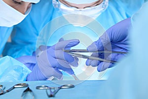 Close up of medical team performing operation. Group of surgeons at work in operating theater