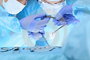 Close up of medical team performing operation. Group of surgeons at work in operating theater