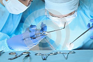 Close up of medical team performing operation. Group of surgeons at work in operating theater