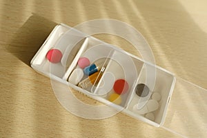 close-up medicinal drugs, capsules, pills, vitamins in pillbox organizer for week, concept controlling regular medication intake,