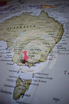 Close up of Melbourne pin pointed on the world map with a pink pushpin