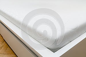Close up of memory foam mattress on the bed frame at sleeping room. Comfort, choosing mattress