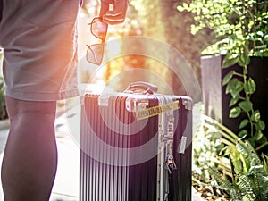 Close up Men holding sunglasses with traveling bag. Summer holiday traveling concept design banner with copyspace