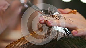 Close up of men`s hair cutting scissors in a beauty salon. Frame. Close up of a haircut at a hair saloon. Professional