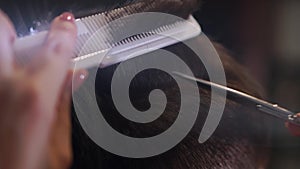 Close up of men`s hair cutting scissors in a beauty salon. Frame. Close up of a haircut at a hair saloon. Professional