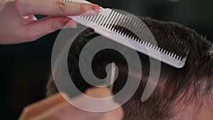 Close up of men`s hair cutting scissors in a beauty salon. Frame. Close up of a haircut at a hair saloon. Professional