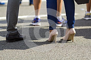Close up of men and women legs in different shoes, high heels wa