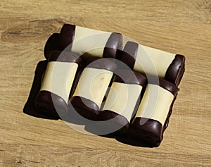 typical dutch sweet cookie called & x22;mergpijpje& x22; covered with white marzipan, on a wooden background