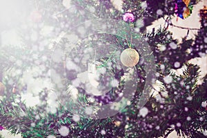 Close up Merry Christmas and Happy New Year on close up of decorated tree with snow bokeh background