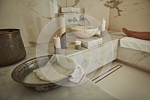 Close up of metal basin in Turkish bath with lady in the background