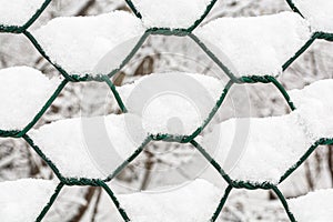 Close-up of a metal chain-link fence with adhering white