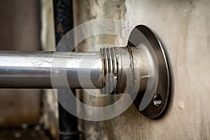 close-up of metal downpipe, with screws securing it to the wall