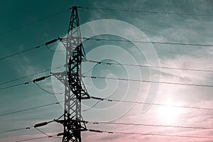 Close-up of metal electric high voltage pylon on background of sunrise sky.