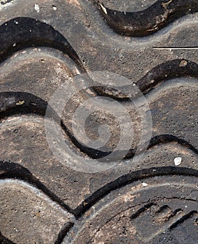 Close-up of the metal manhole cover in the sunshine.