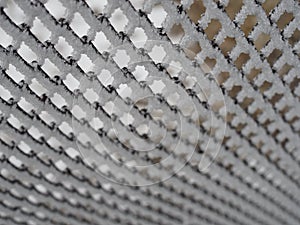 Close-up metal mesh covered with a thick layer of snow in the cells