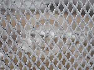 Close-up metal mesh covered with a thick layer of snow in the cells
