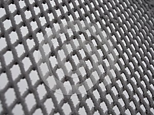 Close-up metal mesh covered with a thick layer of snow in the cells