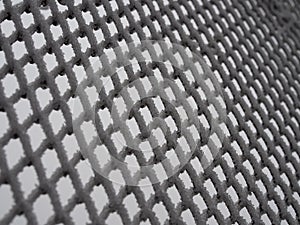 Close-up metal mesh covered with a thick layer of snow in the cells