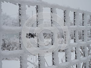 Close-up metal mesh covered with a thick layer of snow in the cells