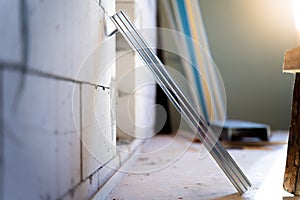 Close-up of a metal profile prepared for a frame wall. Cropped and curved end of a metal U profile on a blurred background